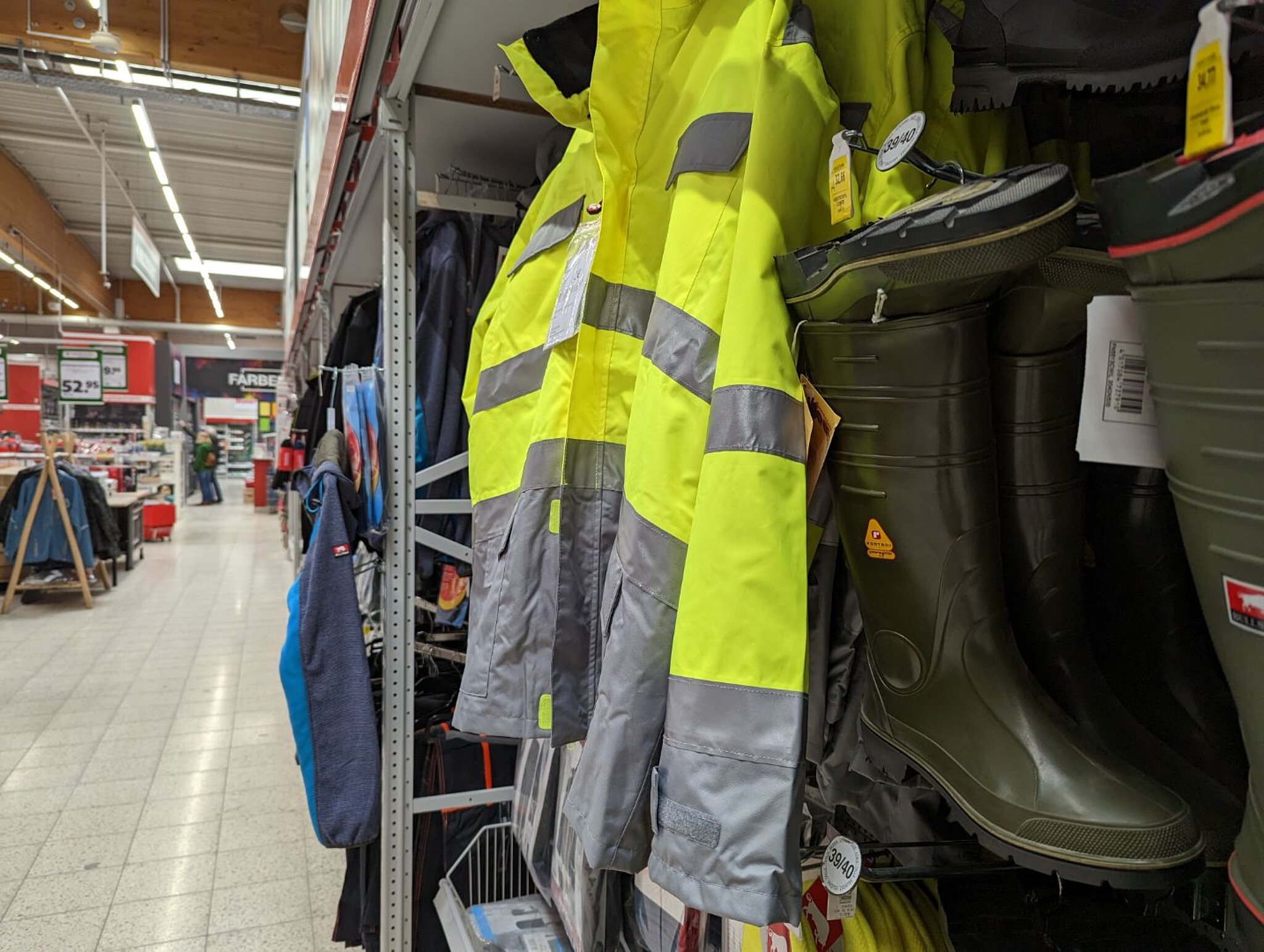 Arbeitskleidung rechtseitig mit Jacke in neongelb/grau und oliven Gummistiefeln